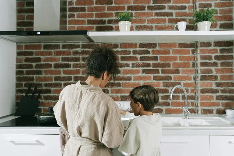 A parent and child cooking together in the kitchen