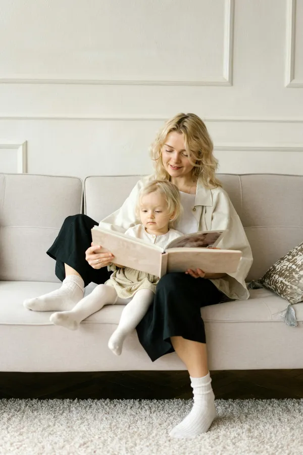 A mother and daughter reading together on the couch